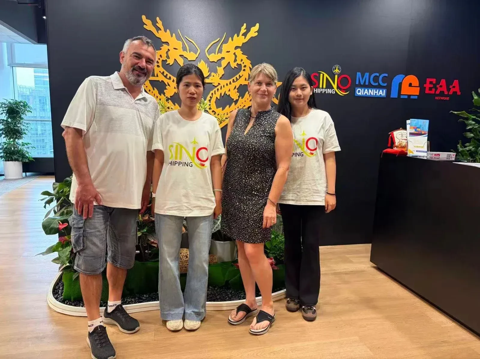 Vi tager imod et europæisk par foran vores partner-logo væg i Guangzhou.