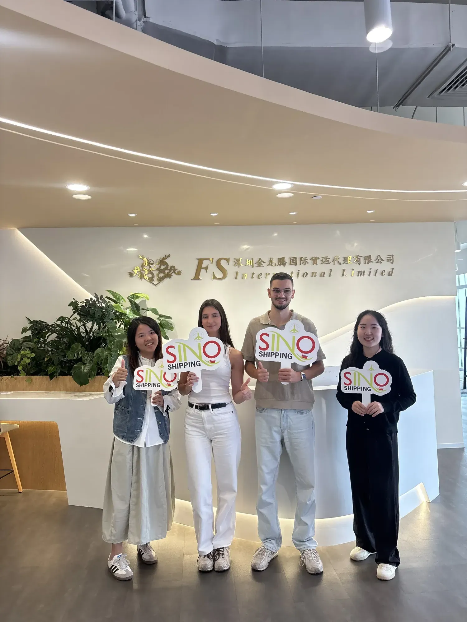 Gruppefoto med Rayan og Chloe, der holder specialfremstillede SINO padler på vores Shenzhen-kontor.