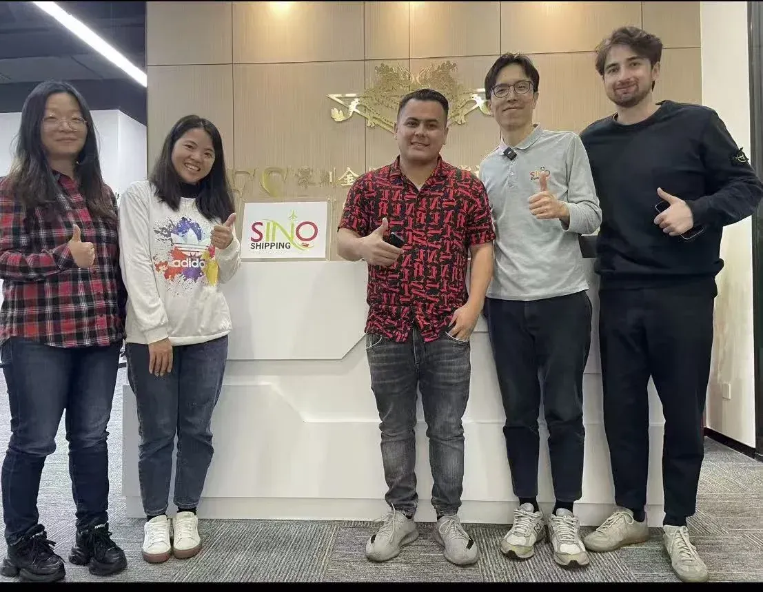 Vores Shenzhen-team tager imod tre internationale kunder foran SINO Shipping-logoet.