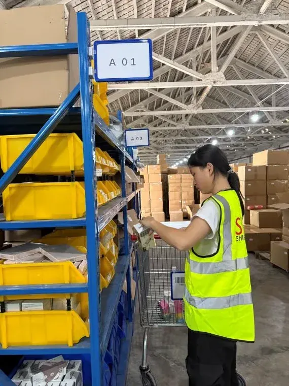 在履约仓库有序的蓝色货架（A01–A03）拣货。