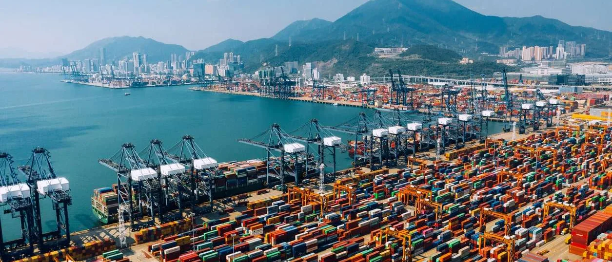 Containerterminalen i Ningbo-Zhoushan med portalkranar som lastar ett containerfartyg i skymningen