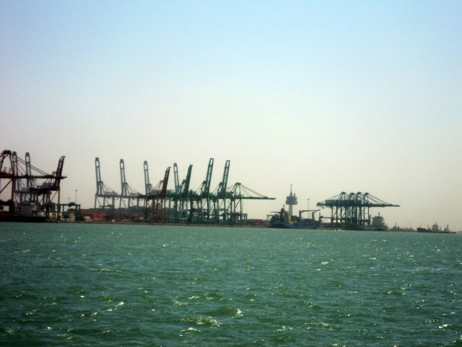 Portalkranar längs containerkajerna i Tianjin Xingang, sedda från vattnet