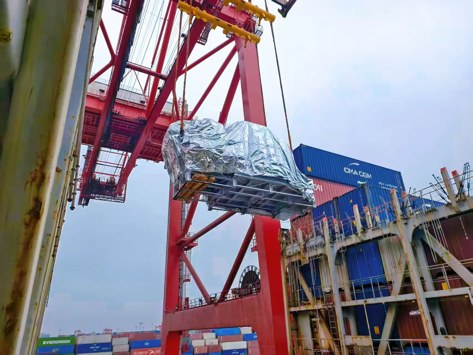 Containere læsses på et containerskib ved en kinesisk terminal, fragt håndteres af SINO Shipping