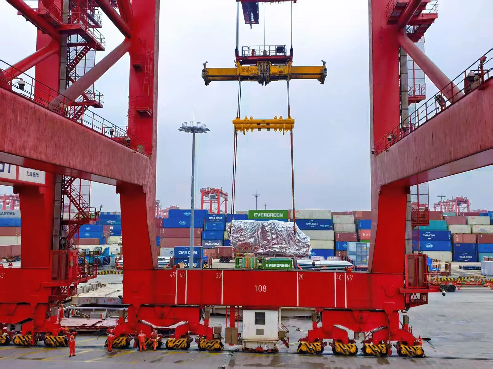 Portalkran lastar flat rack vid kinesisk containerterminal, hanterat av SINO Shipping