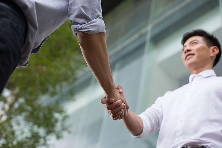 Top 8 Tips On Importing Products From China 2 A picture of a person shaking hands with a Chinese manufacturer or supplier, representing the importance of establishing a relationship with a reliable source.